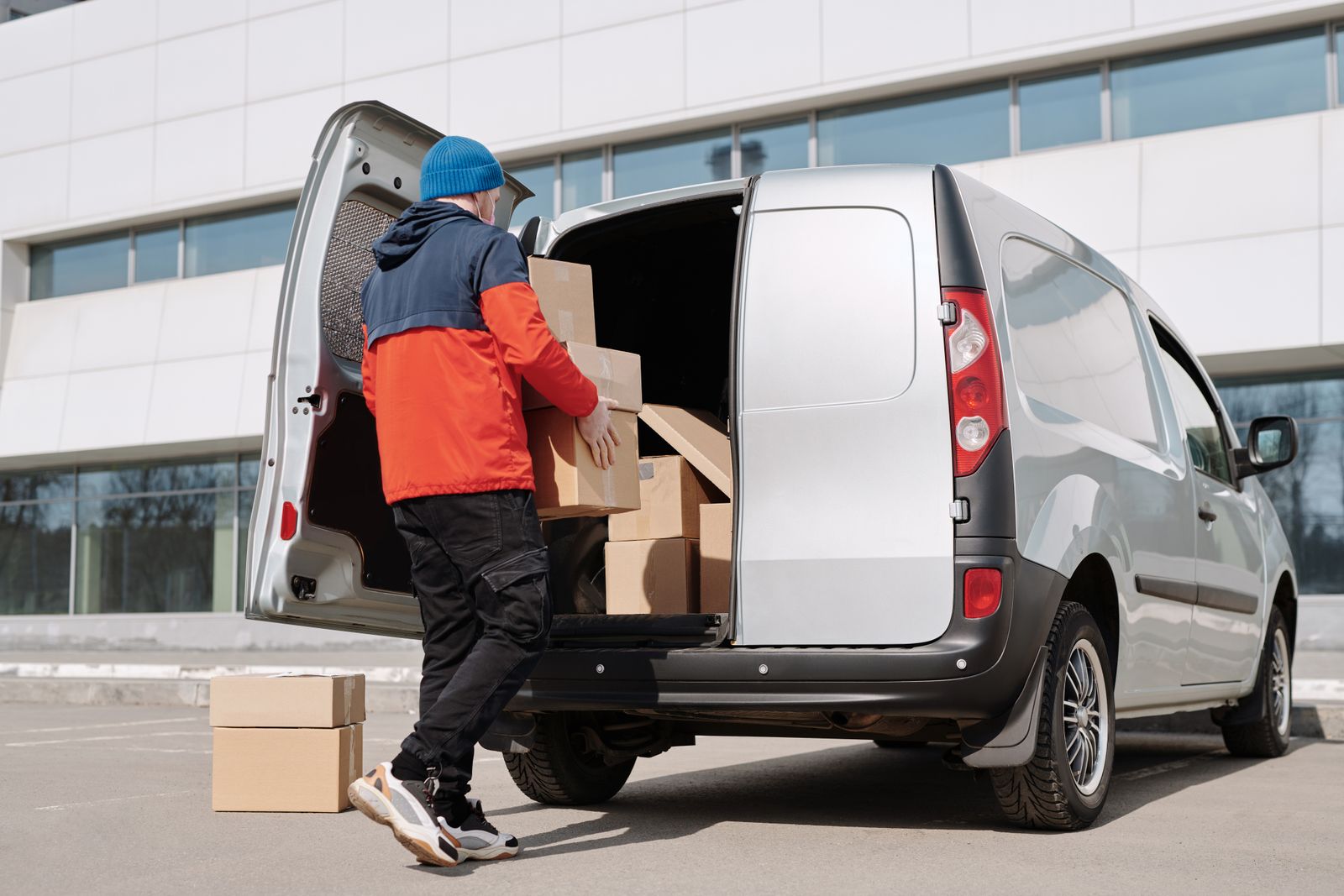 Delivery worker loading boxes into a van — dispatch systems in action